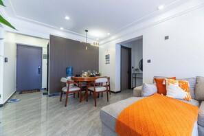 A modern living room with a sofa, a dining table with chairs, and a kitchen area. - Cozy 2 BR with Heater,Gym,Pool,ample parking on 3floors at Lavington,Nairobi (Nairobi)