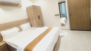 Een slaapkamer met een bed, een kledingkast, een plafondventilator en een raam met zonwering.