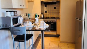 Une cuisine compacte équipée d’un four à micro-ondes, d’une cuisinière et d’un réfrigérateur.