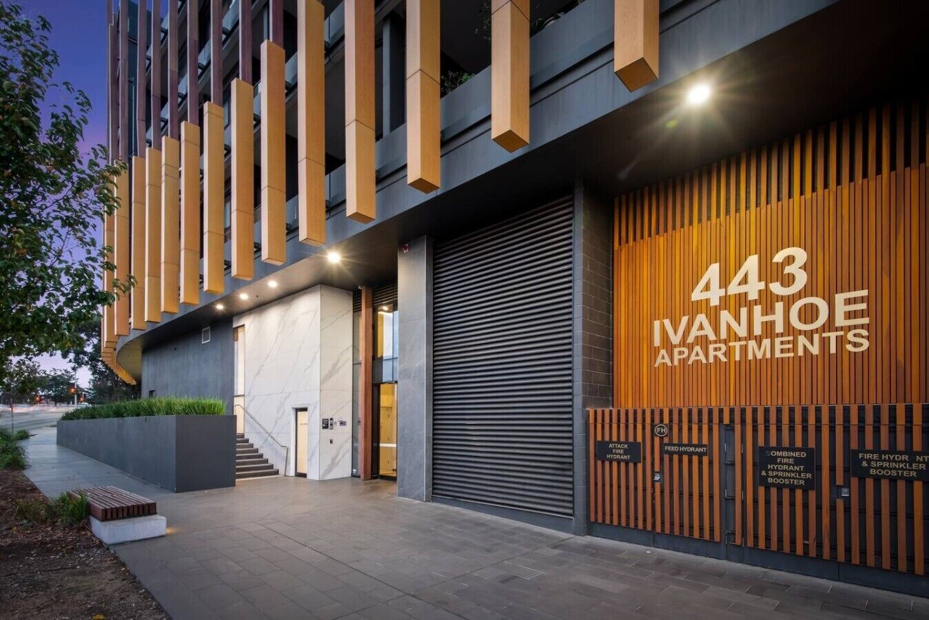 A modern building with a sign for '443 Ivanhoe Apartments.'