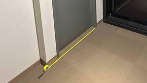 A door with a sign indicating room number 1004, a door handle, and a yellow measuring tape on the floor. - Austin Hospital | City views | Gym & Pool | 2B1B (Ivanhoe)