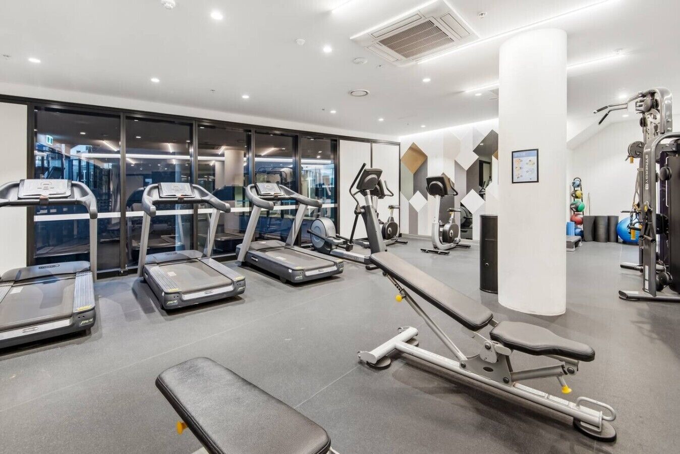 A gym with treadmills, a bench press, and weight machines.