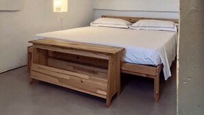 A bedroom with a wooden bed, a nightstand, and a wall-mounted light. - Le Lamie di Ostuni - a traditional country house with a pool (Puglia)