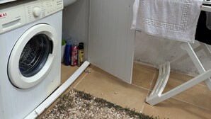 A laundry area with a washing machine, a drying rack, and laundry supplies. - Le Lamie di Ostuni - a traditional country house with a pool (Puglia)