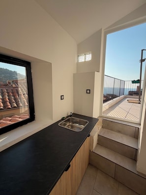 Eine moderne Küche mit Fenster, Spüle und Blick auf die Stadt.