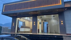 Un edificio moderno con techo plano, amplios ventanales de vidrio y fachada de madera.