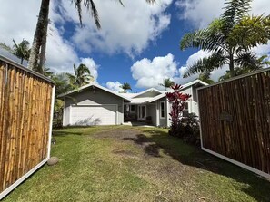 A residential property with a garage, a covered porch, and a well-maintained lawn.