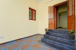 Una escalera que lleva a una puerta con un ventanal arriba.