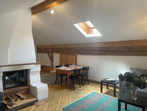 A dining area with a table set for four, a fireplace, and a skylight. - Plaz Aldier, (Sent) by Interhome (Sent)