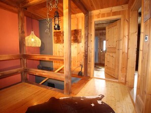 A wooden interior with a cowhide rug, wooden beams, and a hanging lantern. - Ferienhaus Chas'alba, (Sta. Maria Val Müstair) by Interhome (Sta. Maria GR)
