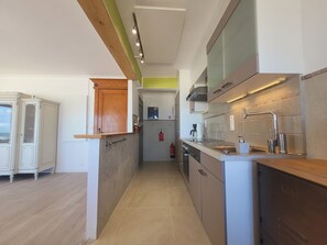 A modern kitchen with a wooden countertop, built-in cabinets, and a stainless steel sink. - Apartment With Panoramic Sea Views (Middelkerke)