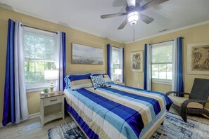 A bedroom with a bed, a chair, a ceiling fan, and artwork on the walls. - Back Deck, Grill, Yard! New Bern Family Home (New Bern)