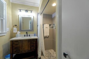 A bathroom with a vanity, mirror, towel rack, and shower area. - Back Deck, Grill, Yard! New Bern Family Home (New Bern)