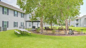Un quartier résidentiel doté d’un patio, d’une table de pique-nique et d’un barbecue.