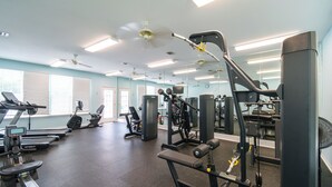 Une salle de sport équipée de machines de cardio, de matériel de musculation et de miroirs aux murs.