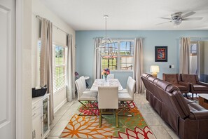A dining area with a table, chairs, and a sofa. - 4BR/3BA Championsgate Villa With Private Pool (Davenport)