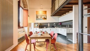 Eine moderne Küche mit Essbereich, Holzboden und einer Treppe.