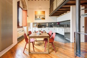 Eine moderne Küche mit Essbereich, Holzboden und einer Treppe.