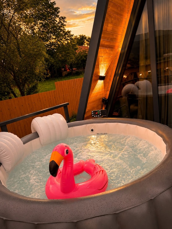 A hot tub with a pink flamingo float, surrounded by a wooden deck and a glass enclosure. - A-frame with lake view near Stepanavan (Vardablur)