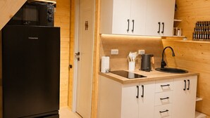 A compact kitchen with a black refrigerator, a microwave, white cabinets, and a wooden ceiling. - A-frame with lake view near Stepanavan (Vardablur)
