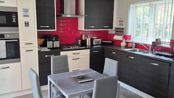 Coffee/tea maker, fridge, cookware/dishes/utensils
