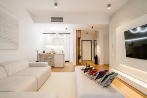 A modern living room with a sofa, a coffee table, and a bookshelf with books. - Urban Deluxe Igloo Jacuzzi Terrace (București)