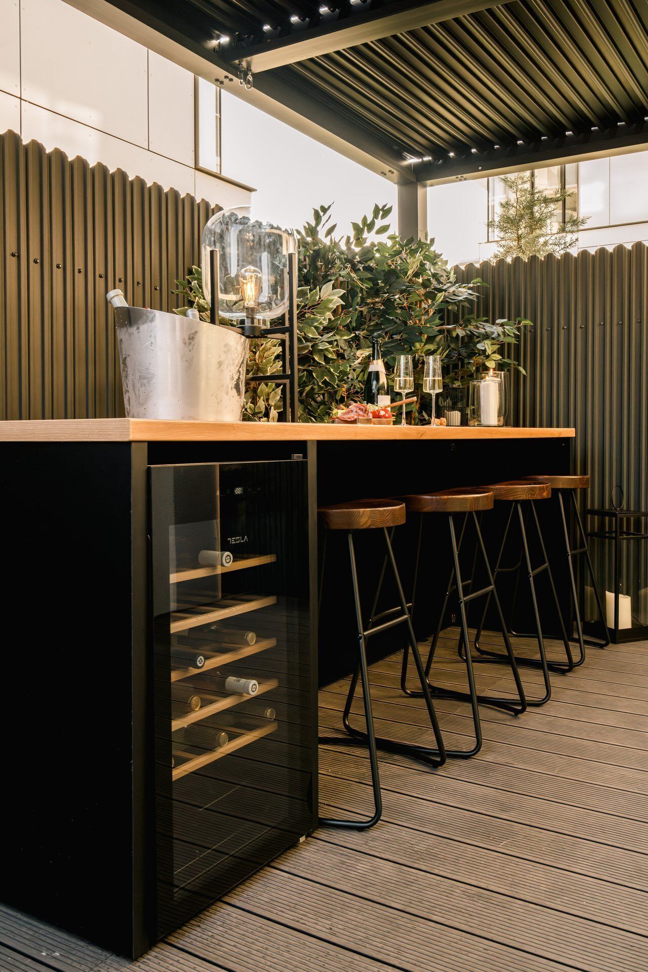 Eine moderne Küche mit integriertem Kühlschrank, Barhocker und einer Arbeitsplatte mit einem Glasbehälter und Flaschen.