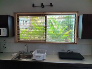 A kitchen with a window, a sink, and cabinets. - Marina Loft #103, 1 floor (Playa Del Coco)