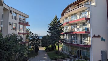 A multi-story hotel with balconies, a reception area, and a view of the sea.