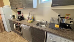 A compact kitchen with a dishwasher, microwave, and a coffee machine. - Komfortables Apartment mit 2 Schlafzimmern direkt am Strand in Nessebar (Nesebar)