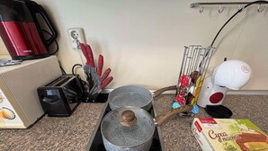 A kitchen with a stove, pots, a coffee maker, a toaster, and a box of Cucumber Cream. - Komfortables Apartment mit 2 Schlafzimmern direkt am Strand in Nessebar (Nesebar)