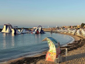 Ein Strand mit Wasserrutschen und Strandsonnenschirmen.