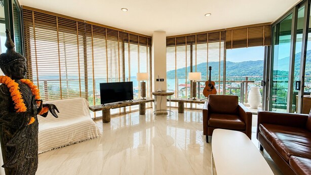 Ein modernes Wohnzimmer mit großem Fernseher, Sitzgelegenheit und einer Statue.