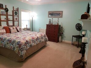 A bedroom with a large bed, dresser, and a wall-mounted fan. - Lake Tobesofkee 3 Bedroom Home (Macon)