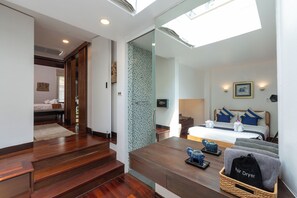 A hotel room with a bed, a desk, and a bathroom. - Surin Lake Villa (Thalang District)