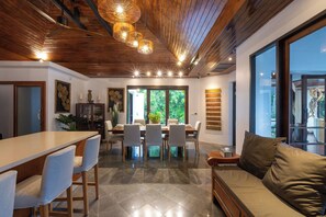 A modern interior with a dining area, a sofa, and a bar. - Surin Lake Villa (Thalang District)