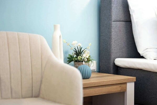 Een bank, een houten bijzettafeltje en een vaas met bloemen.