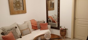 Une pièce comprenant un canapé, un miroir et un élément décoratif mural.