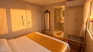 Una camera d'albergo con un letto, uno specchio, una doccia e una finestra con tende.