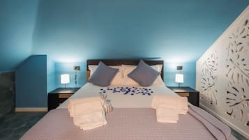 Habitación de hotel con cama, dos mesitas de noche, un panel decorativo en la pared y cabecero.