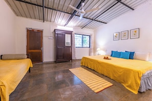 A room with two beds, a wooden wardrobe, a window with curtains, and a ceiling fan. - CosmicStays The Outhouse (Mulshi)