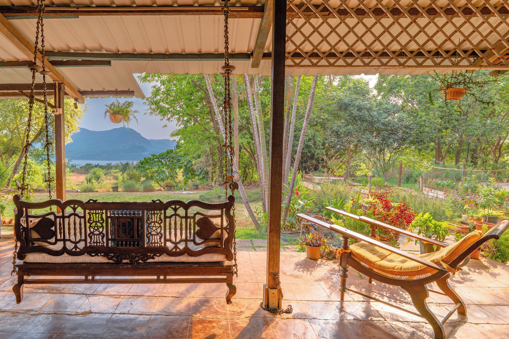 Un banco de madera para columpios bajo una pérgola, con vistas a un paisaje montañoso.