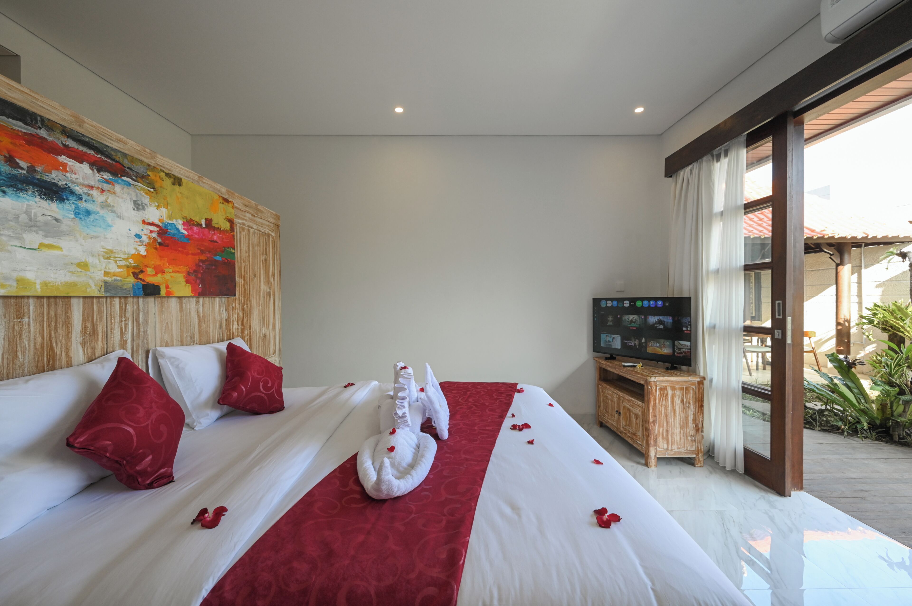 Habitación de hotel con una cama grande, un televisor de pantalla plana y un cuadro en la pared.