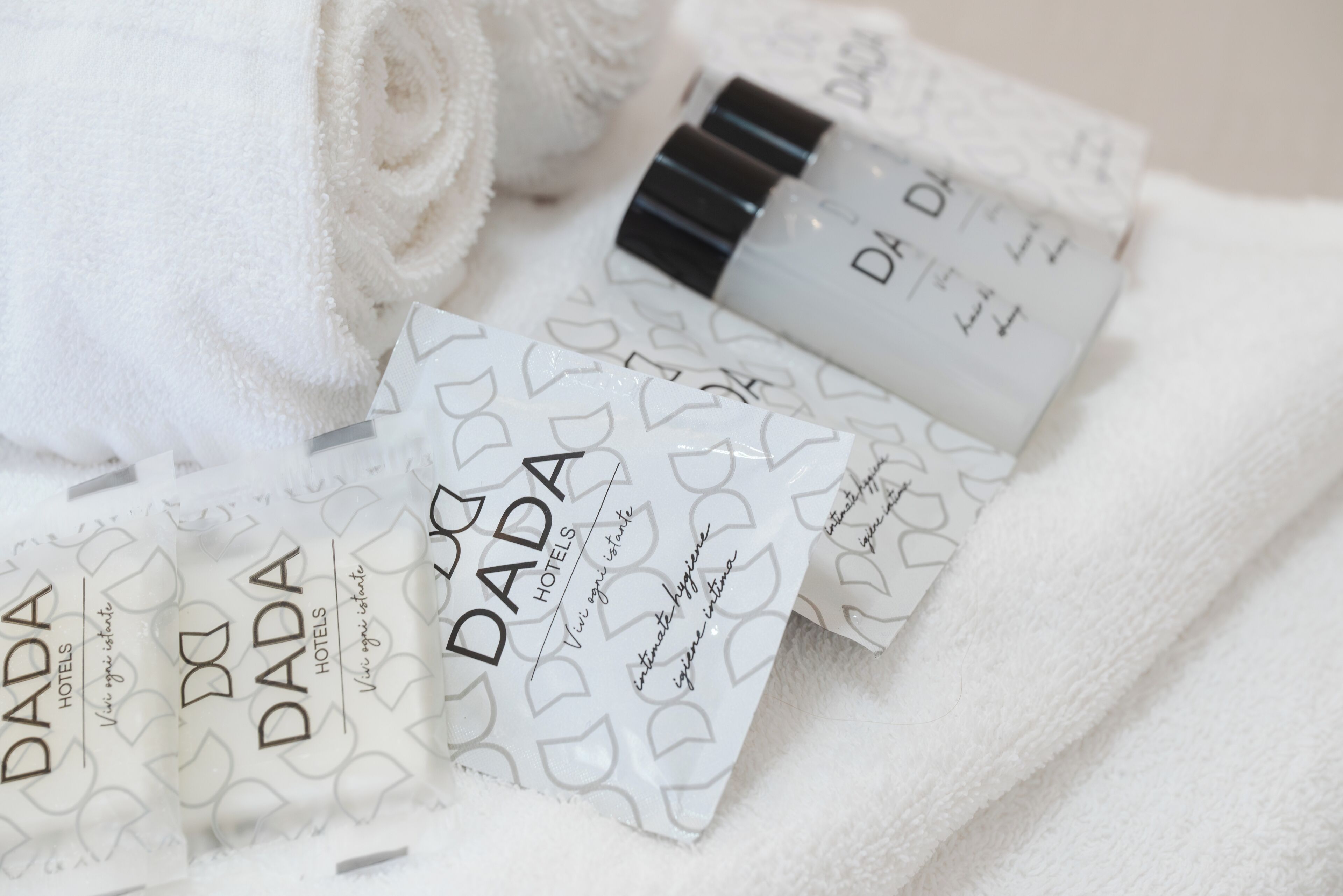 A towel and several DADA branded toiletries.