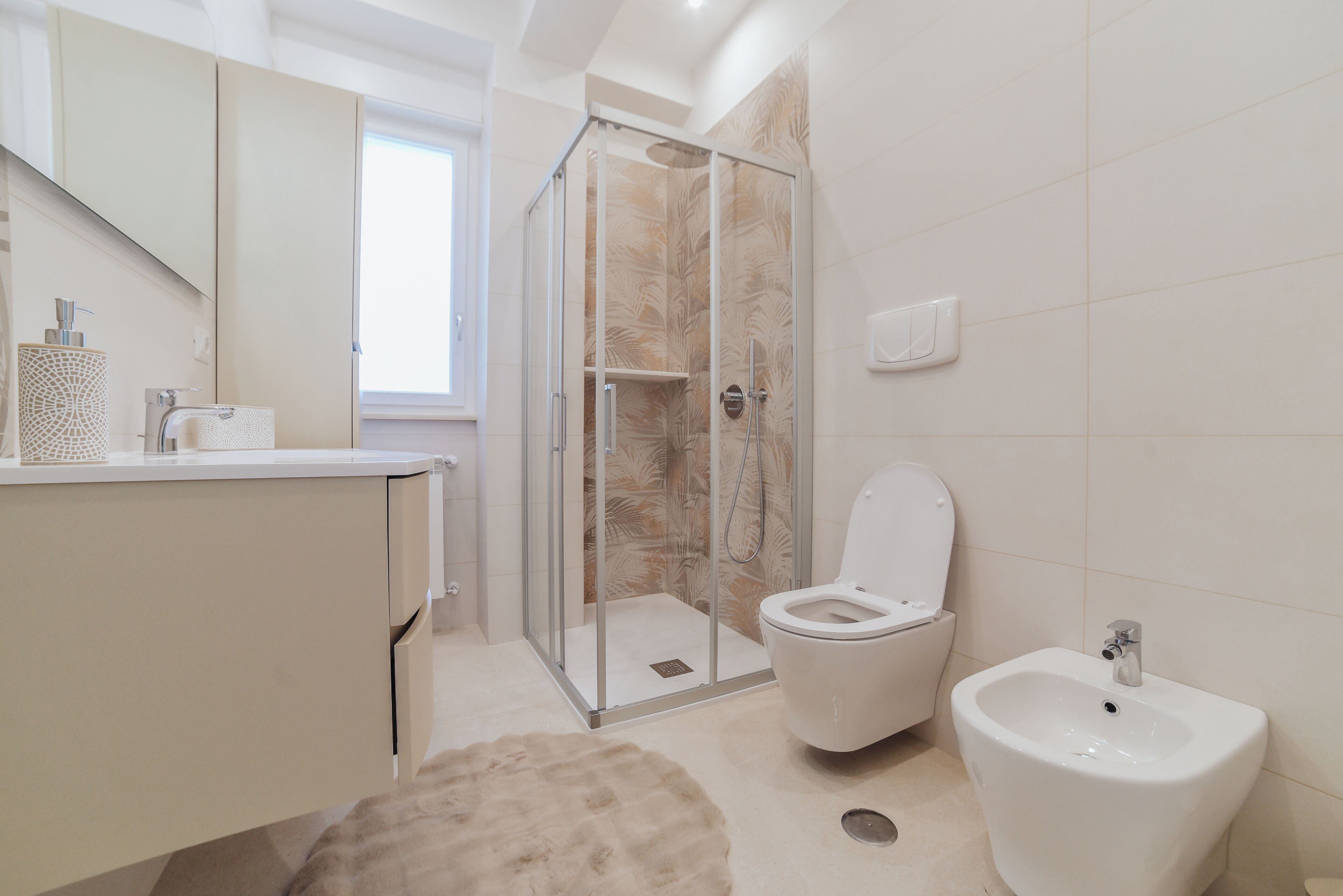Une salle de bain moderne avec une douche à parois de verre, des toilettes et un bidet.