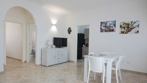 Una sala moderna con comedor, televisor y obras de arte en la pared.