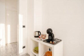 A kitchenette with a coffee maker, kettle, and cups on a white countertop. - ALL AUGUSTEA | Elegant 3BR Retreat in Central Bari  (Bari)