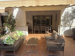 A patio with a sofa, chairs, and a table. There is a sliding glass door leading to an indoor dining area. - Cottage on a golf course (ideal for golf getaways). (Roldan, Torre Pacheco)