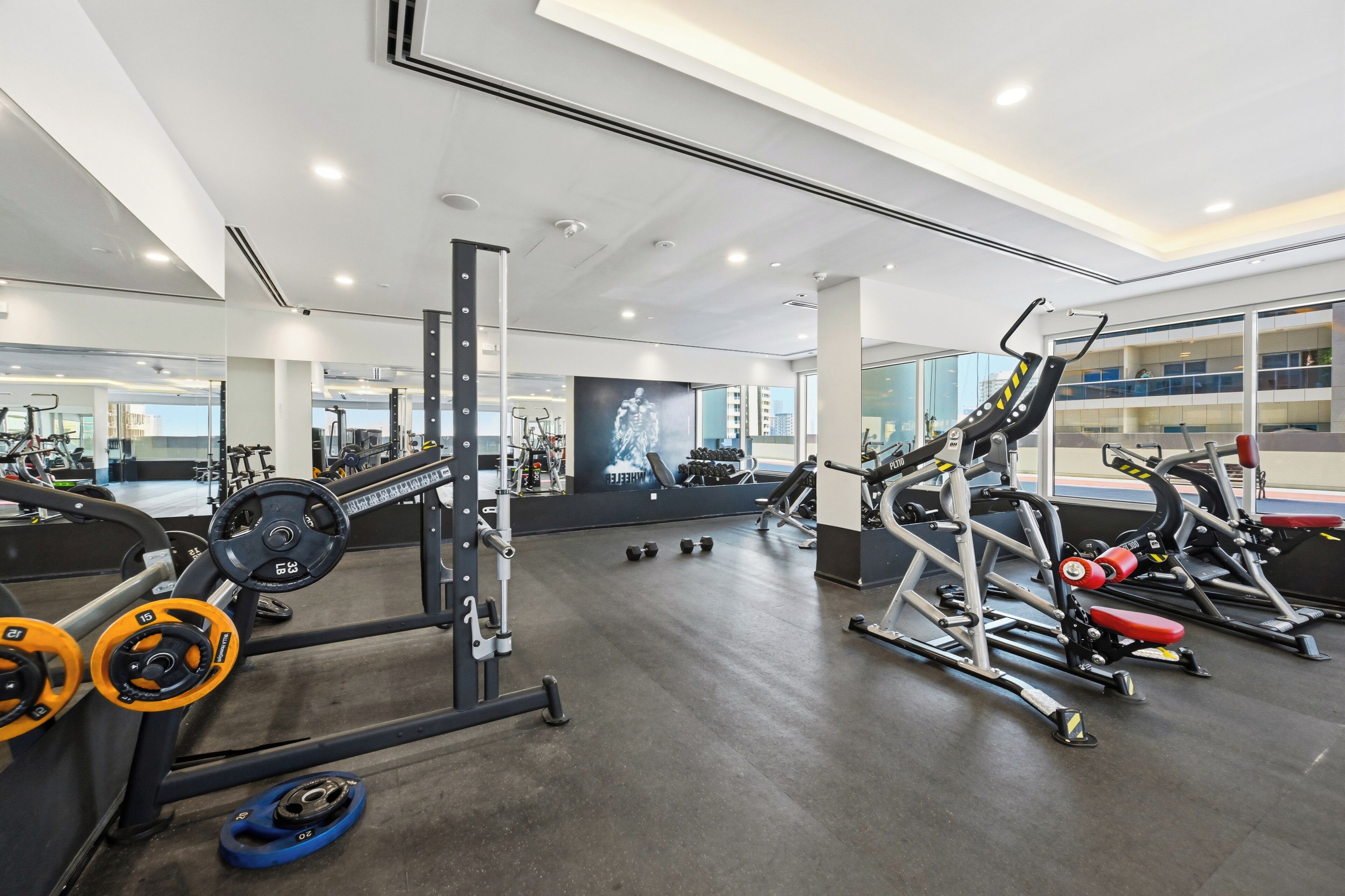 Une salle de sport moderne équipée de divers appareils d’entraînement, notamment des machines à poids et des poids libres.