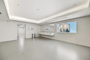 Ein geräumiges, modernes Badezimmer mit großem Fenster, integriertem Waschbecken und Mülleimer.